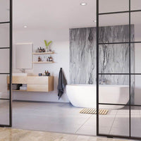 Modern bathroom interior with freestanding tub, marble wall, wooden cabinets, wall-mounted mirror, and glass partition.