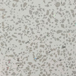 Close-up texture of terrazzo flooring with grey speckles and occasional reflective chips on a light base