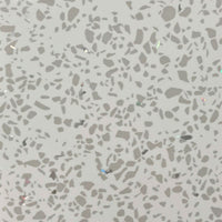Close-up texture of terrazzo flooring with grey speckles and occasional reflective chips on a light base