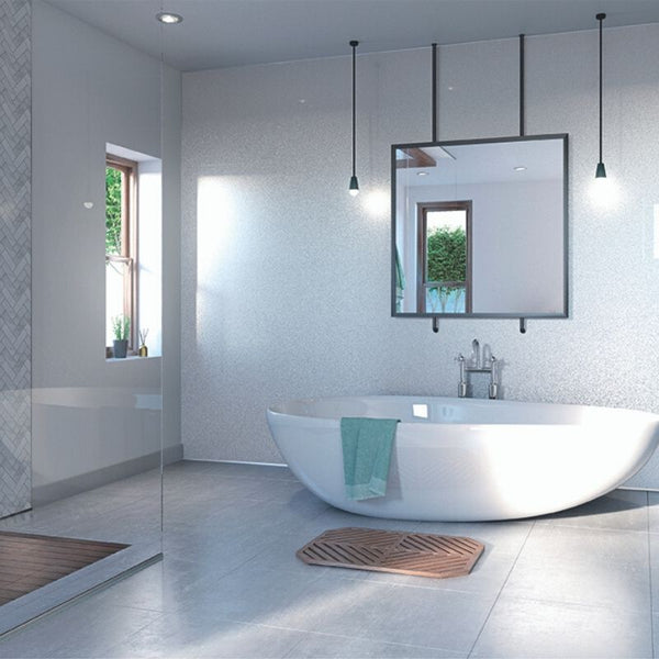 Modern bathroom interior with freestanding tub, pendant lights, large mirror, and a view of greenery through window.