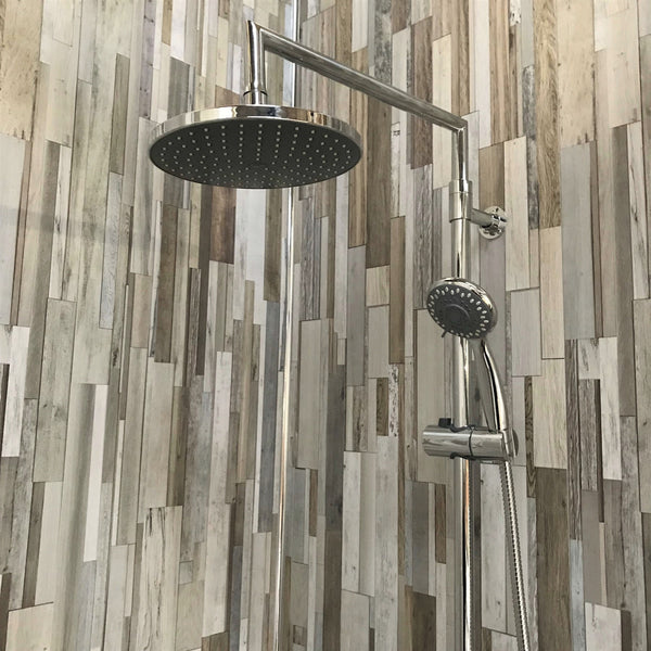 Modern bathroom shower system with rain showerhead and adjustable handheld shower spray against a backdrop of multicolored wood plank tile wall