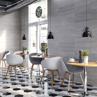 Modern cafe interior with stylish dining tables and chairs, geometric floor tiles, pendant lights, and large window with coffee shop sign.