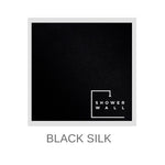 Sample of a black silk-textured shower wall panel with embossed white "Shower Wall" branding and the text "BLACK SILK" below, displayed against a white background for contrast.