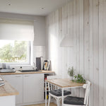 Modern Scandinavian kitchen interior design with white cabinets, wooden countertops, rustic white paneled walls, and a cozy dining area with natural light filtering through a large window.