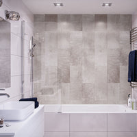 Modern bathroom interior with tiled walls, glass shower partition, white bathtub, towel rack with blue towels, and built-in sink with vanity.