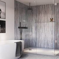 Modern bathroom interior with free-standing bathtub, marble wall, walk-in shower with black fixtures, grey floor tiles, and framed artwork.