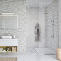 Modern bathroom interior with glass shower, wall-mounted sink, large mirror, tiled walls in shades of gray, and minimalist design elements.